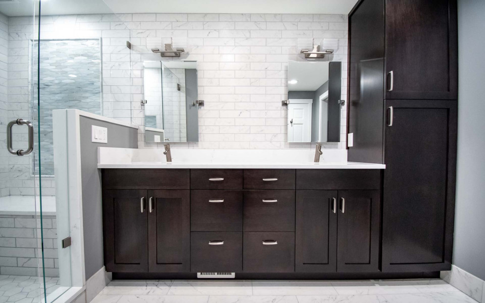 Пример оригинального дизайна: большая главная ванная комната в стиле модернизм с фасадами в стиле шейкер, коричневыми фасадами, душем в нише, раздельным унитазом, белой плиткой, керамической плиткой, серыми стенами, полом из керамической плитки, врезной раковиной, столешницей из искусственного кварца, белым полом, душем с распашными дверями, белой столешницей, сиденьем для душа, тумбой под две раковины и встроенной тумбой