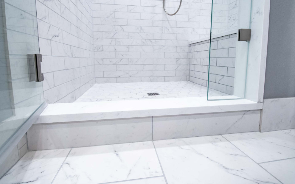 На фото: большая главная ванная комната в стиле модернизм с фасадами в стиле шейкер, коричневыми фасадами, душем в нише, раздельным унитазом, белой плиткой, керамической плиткой, серыми стенами, полом из керамической плитки, врезной раковиной, столешницей из искусственного кварца, белым полом, душем с распашными дверями, белой столешницей, сиденьем для душа, тумбой под две раковины и встроенной тумбой с