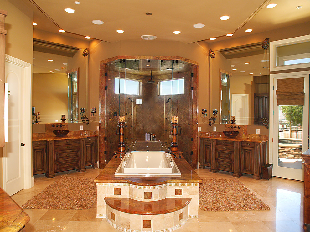 Example of a huge tuscan master brick floor, beige floor, double-sink and vaulted ceiling bathroom design in Las Vegas with brown cabinets, beige walls, an integrated sink, a hinged shower door, brown countertops and a built-in vanity