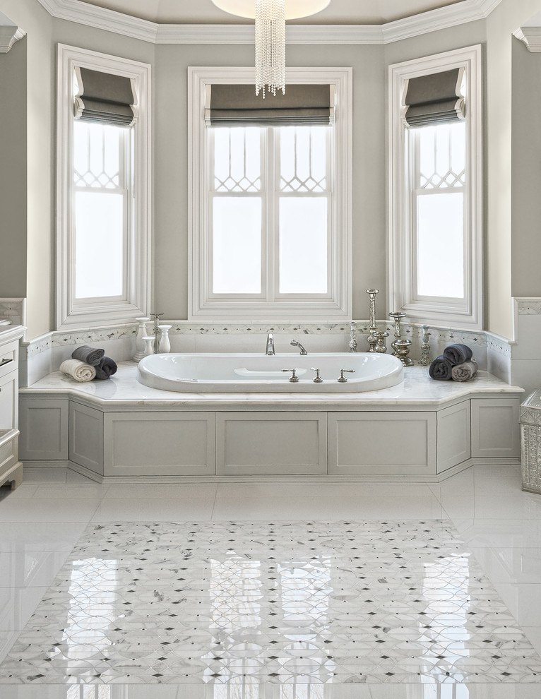 Foto på ett mycket stort vintage en-suite badrum, med ett platsbyggt badkar, beige kakel, marmorkakel, beige väggar, marmorgolv, marmorbänkskiva och vitt golv
