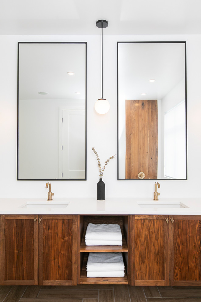 Large contemporary ensuite bathroom in Ottawa with flat-panel cabinets, brown cabinets, a freestanding bath, a double shower, a one-piece toilet, white tiles, ceramic tiles, white walls, ceramic flooring, a wall-mounted sink, engineered stone worktops, brown floors, an open shower and white worktops.