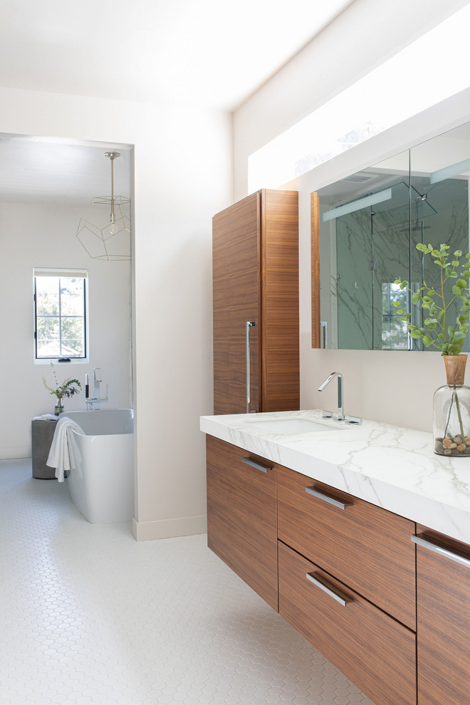 Large trendy master porcelain tile, white floor and double-sink freestanding bathtub photo in Sacramento with flat-panel cabinets, medium tone wood cabinets, white walls, an undermount sink, white countertops and a floating vanity
