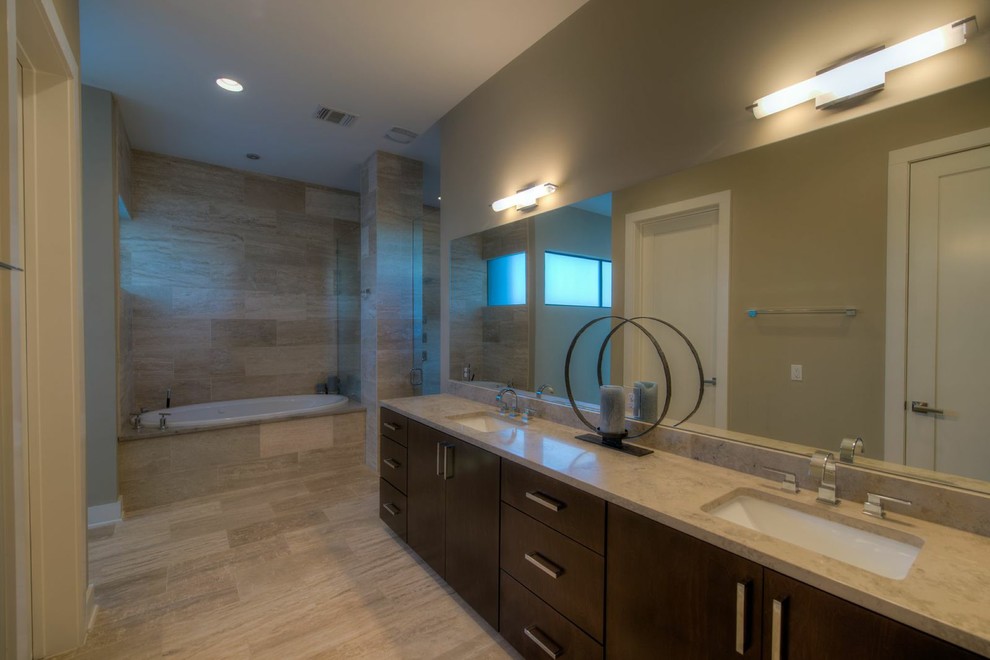 Example of a mid-sized minimalist master beige tile and porcelain tile travertine floor drop-in bathtub design in Austin with an undermount sink, flat-panel cabinets, dark wood cabinets, marble countertops and beige walls