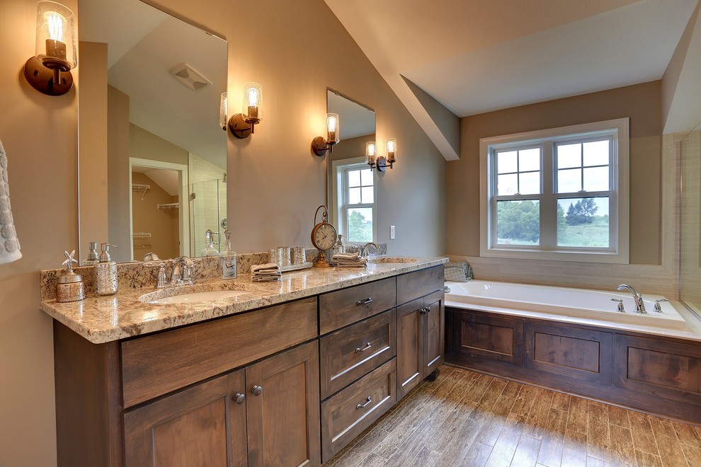 Large traditional ensuite bathroom in Minneapolis with a submerged sink, recessed-panel cabinets, medium wood cabinets, marble worktops, a built-in bath, a corner shower, a one-piece toilet, beige tiles, porcelain tiles, beige walls and porcelain flooring.