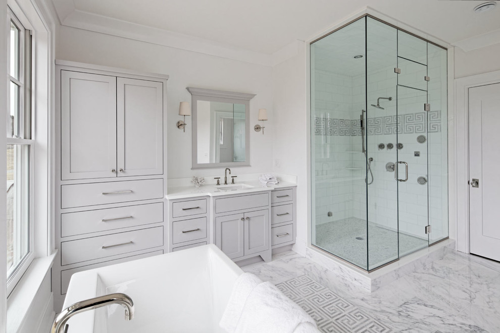 Classic ensuite bathroom in New York with flat-panel cabinets, grey cabinets, a corner shower and marble flooring.