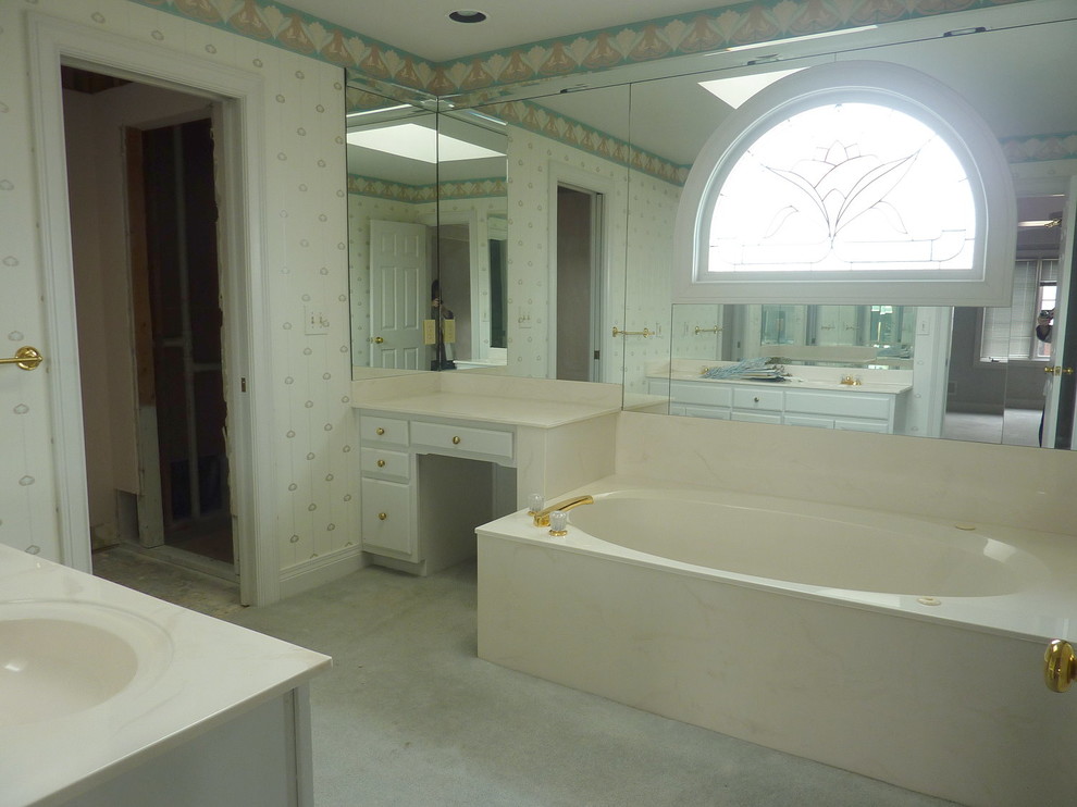 Foto di una stanza da bagno padronale classica di medie dimensioni con ante con bugna sagomata, ante bianche, vasca ad angolo, piastrelle grigie e lavabo integrato