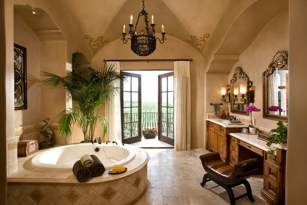 Exemple d'une salle de bain chic avec un lavabo encastré, un bain bouillonnant, une douche d'angle, un carrelage beige et un carrelage de pierre.