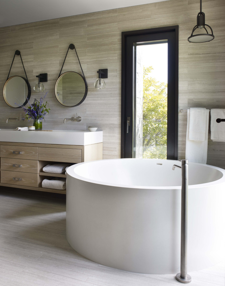 Ispirazione per una grande stanza da bagno padronale minimal con ante in legno chiaro, vasca freestanding, ante lisce, piastrelle grigie, lavabo sottopiano, pavimento grigio e top bianco