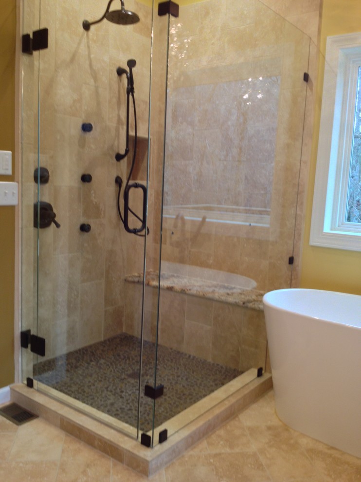 Example of a large classic master beige tile and stone tile travertine floor bathroom design in Charlotte with an undermount sink, furniture-like cabinets, medium tone wood cabinets, granite countertops, a two-piece toilet and beige walls