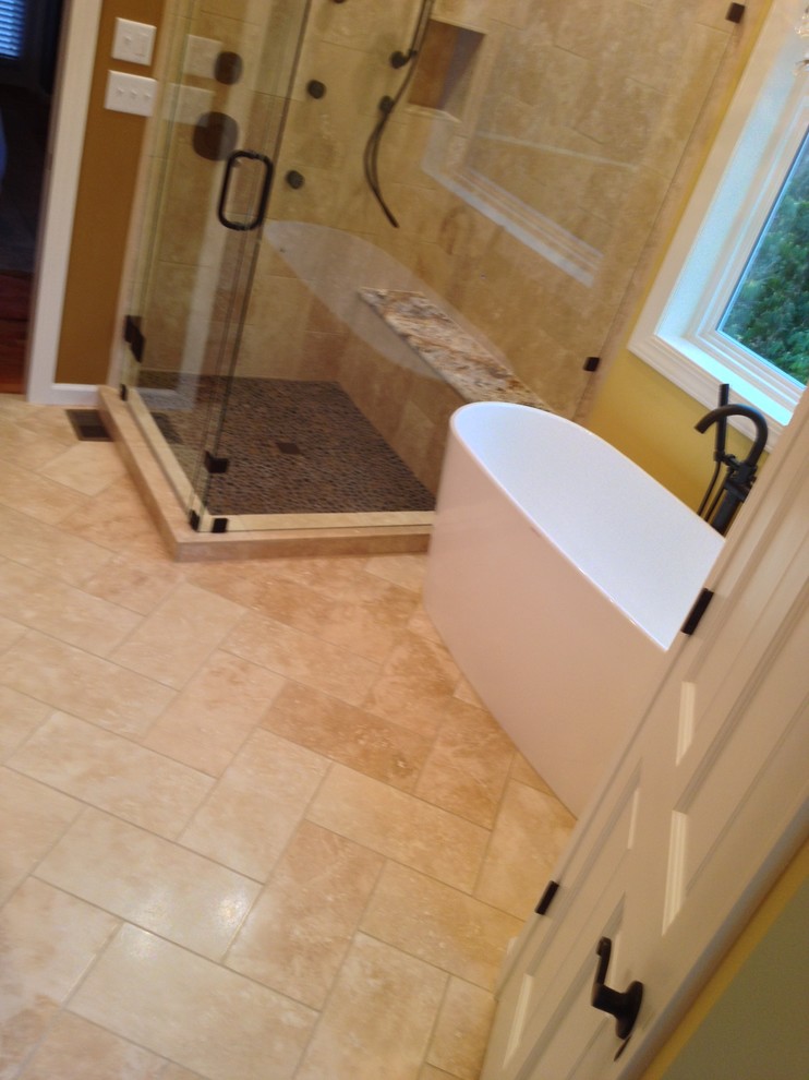 Example of a large classic master beige tile and stone tile travertine floor bathroom design in Charlotte with an undermount sink, furniture-like cabinets, medium tone wood cabinets, granite countertops, a two-piece toilet and beige walls