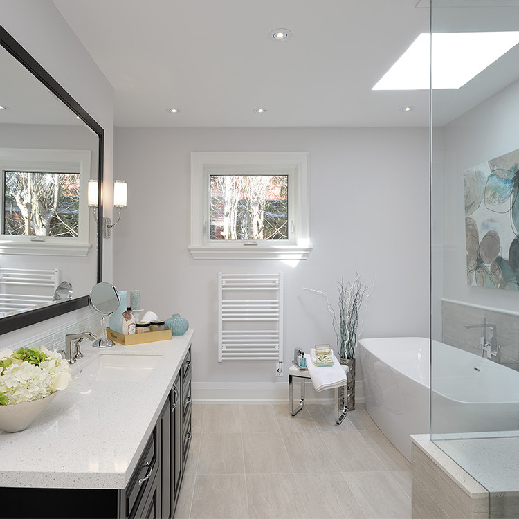 Inspiration for a medium sized classic ensuite bathroom in Toronto with raised-panel cabinets, dark wood cabinets, a freestanding bath, a corner shower, beige tiles, porcelain tiles, grey walls, porcelain flooring, a submerged sink and solid surface worktops.