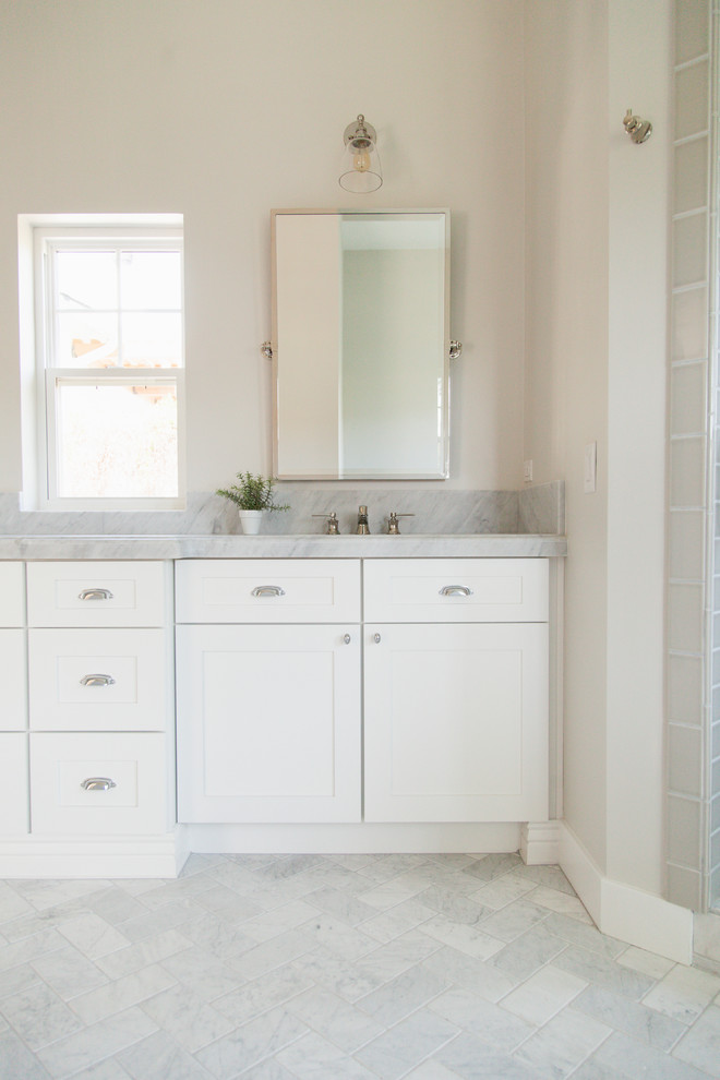 Foto de cuarto de baño principal tradicional de tamaño medio con armarios estilo shaker, puertas de armario blancas, paredes grises, suelo de mármol y encimera de mármol