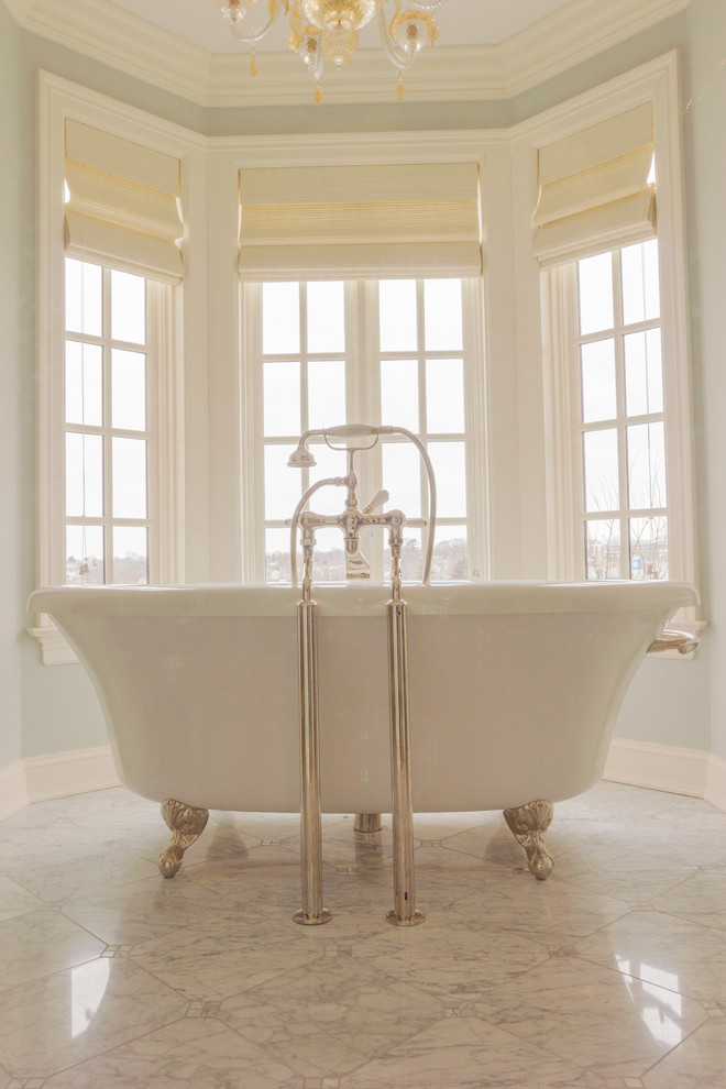Cette image montre une très grande salle de bain traditionnelle avec des portes de placard blanches, un plan de toilette en calcaire, une baignoire sur pieds, une douche double, un carrelage blanc et un mur bleu.