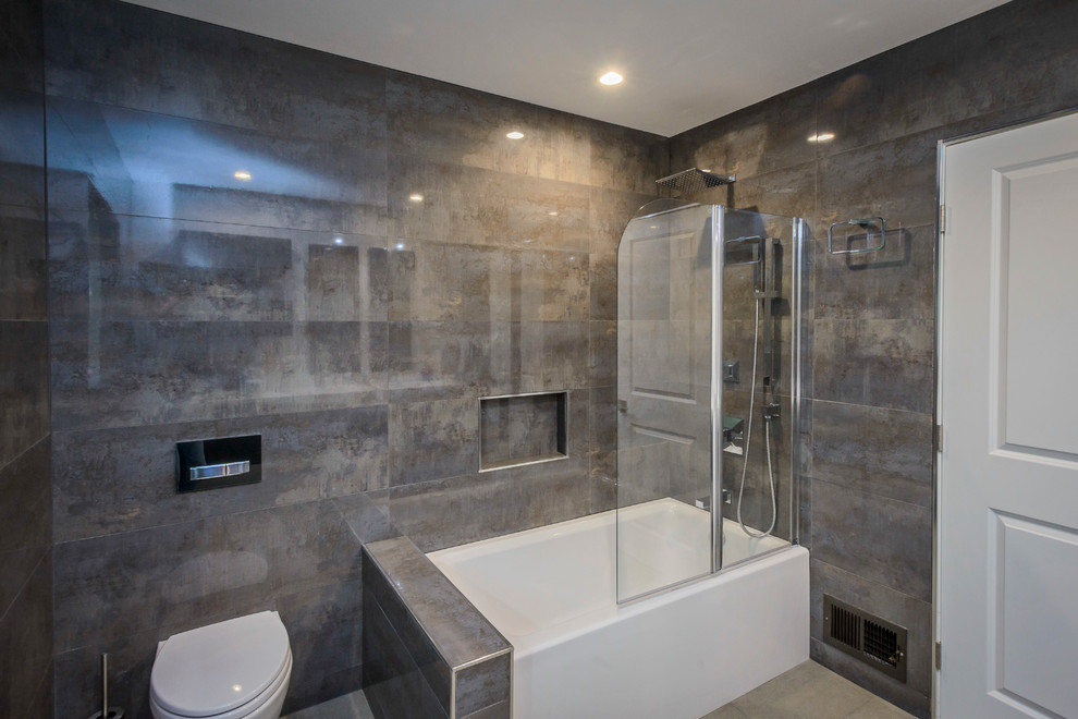 Immagine di una grande stanza da bagno padronale moderna con lavabo integrato, ante lisce, ante grigie, vasca ad angolo, vasca/doccia, WC sospeso e pareti grigie