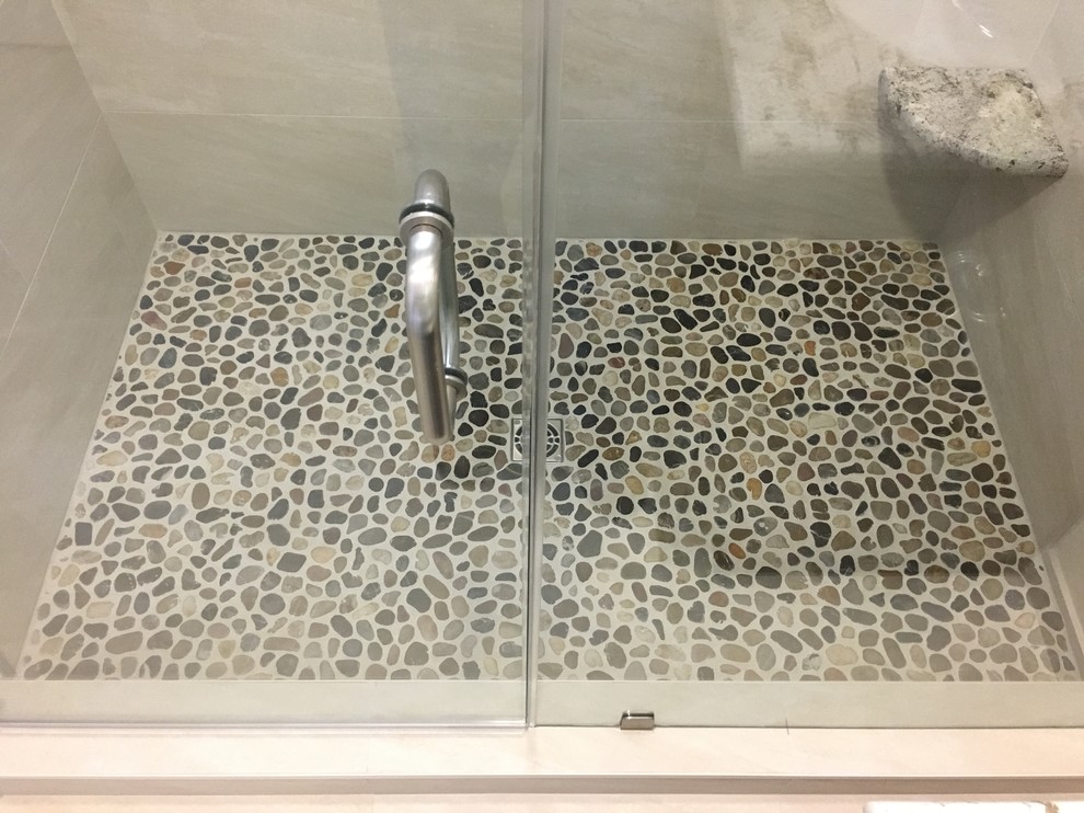 Modern inredning av ett mellanstort en-suite badrum, med en dusch i en alkov, beige kakel, porslinskakel, beige väggar, klinkergolv i småsten, flerfärgat golv och dusch med gångjärnsdörr