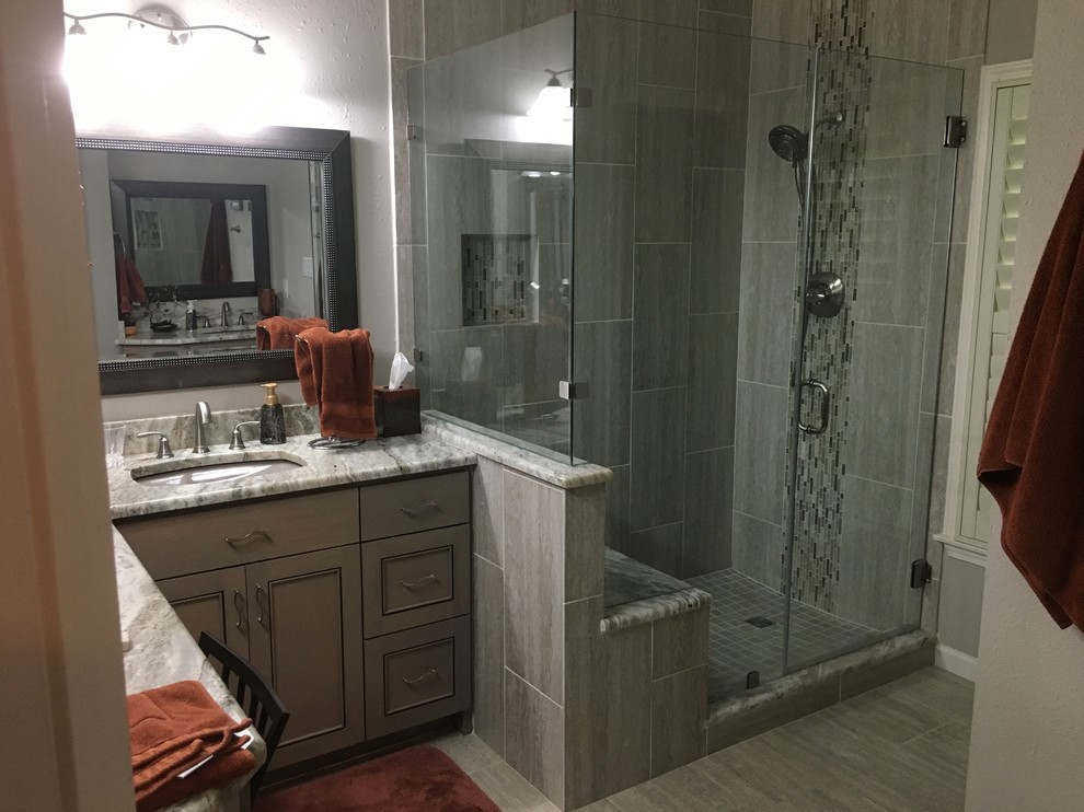 Inspiration for a medium sized contemporary ensuite bathroom in Austin with recessed-panel cabinets, grey cabinets, a corner shower, grey tiles, porcelain tiles, grey walls, porcelain flooring, a submerged sink, marble worktops, grey floors and a hinged door.