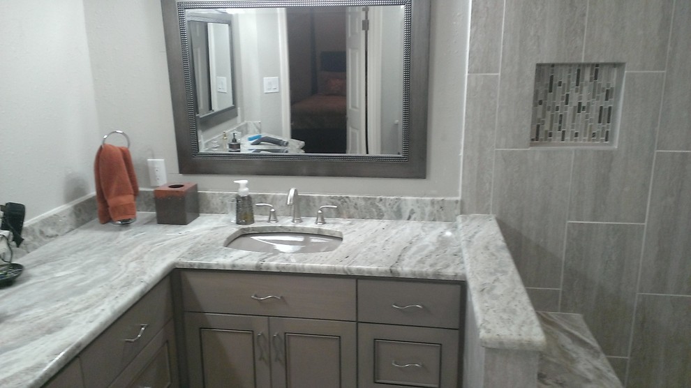 Example of a mid-sized trendy master gray tile and porcelain tile porcelain tile corner shower design in Austin with an undermount sink, recessed-panel cabinets, gray cabinets, marble countertops and gray walls