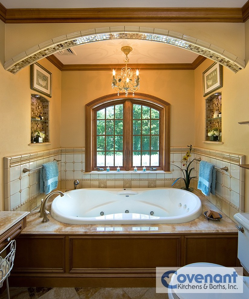 Стильный дизайн: главная ванная комната в классическом стиле с фасадами с декоративным кантом, фасадами цвета дерева среднего тона, столешницей из оникса, ванной в нише, белой плиткой, керамической плиткой и бежевыми стенами - последний тренд