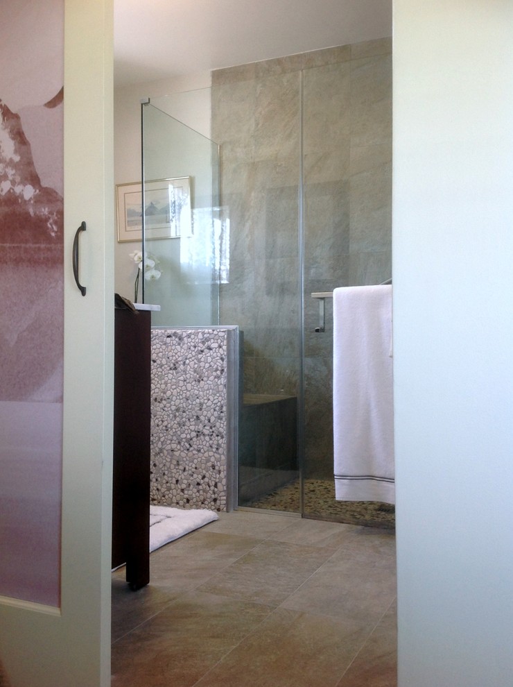 Medium sized contemporary ensuite bathroom in Los Angeles with a submerged sink, flat-panel cabinets, dark wood cabinets, marble worktops, a built-in shower, a two-piece toilet, grey tiles, pebble tiles, grey walls, porcelain flooring and a hinged door.