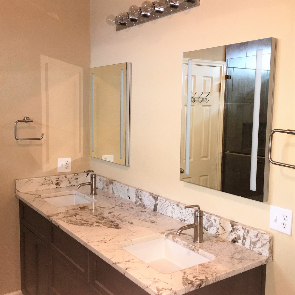 Inspiration for a mid-sized contemporary master porcelain tile and brown floor bathroom remodel in Austin with recessed-panel cabinets, gray cabinets, beige walls, an undermount sink, granite countertops and multicolored countertops