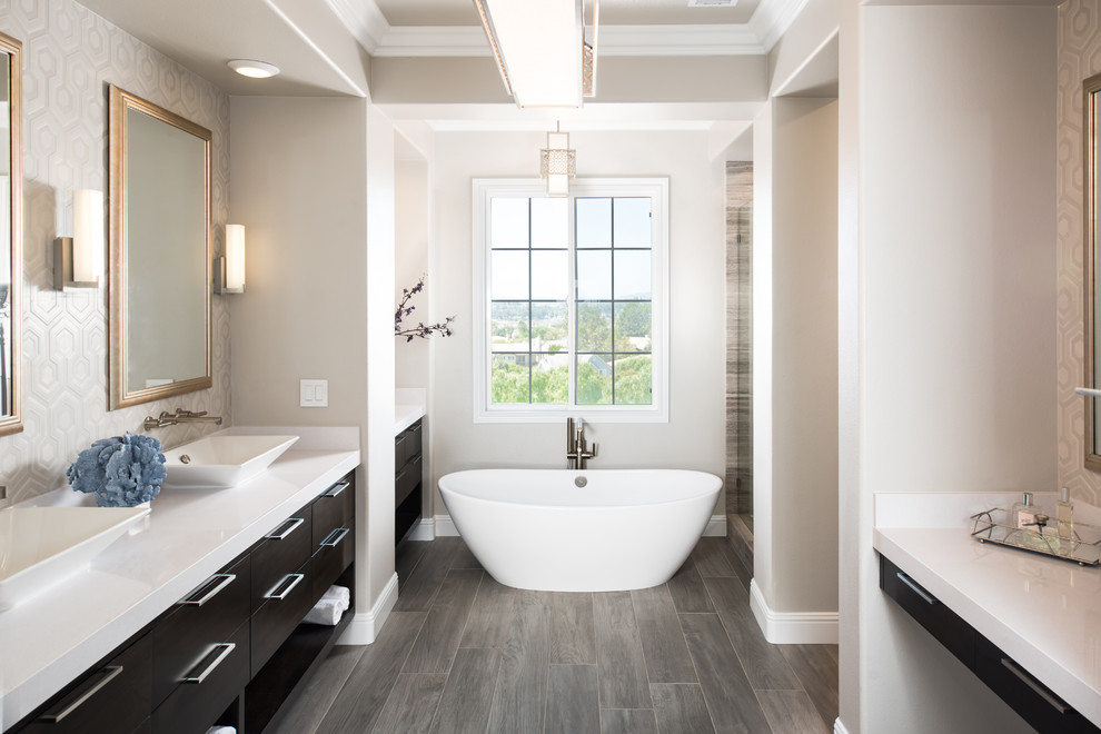 Design ideas for a traditional bathroom in Orange County with flat-panel cabinets, black cabinets, a freestanding bath, an alcove shower and grey tiles.