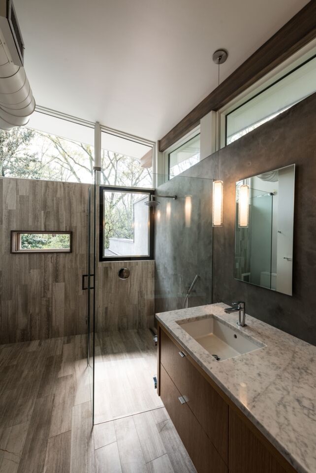 Modern inredning av ett mellanstort badrum, med släta luckor, skåp i mellenmörkt trä, en hörndusch, grå väggar och ett nedsänkt handfat