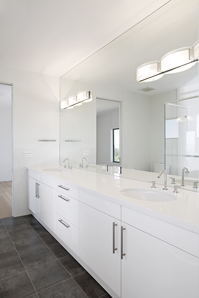 Свежая идея для дизайна: ванная комната: освещение в современном стиле с врезной раковиной, плоскими фасадами, белыми фасадами, серой плиткой, двойным душем, белыми стенами и полом из керамической плитки - отличное фото интерьера