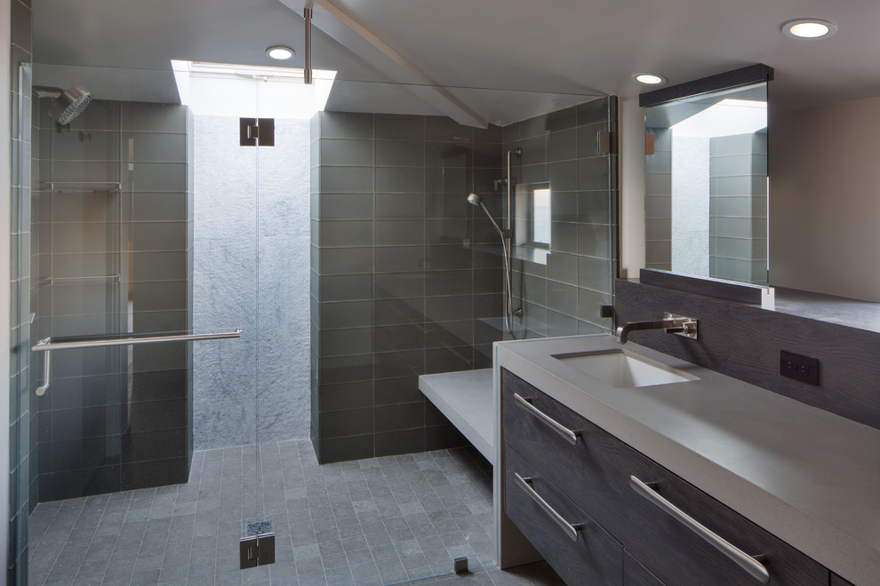 This is an example of a medium sized contemporary ensuite bathroom in San Francisco with a submerged sink, flat-panel cabinets, dark wood cabinets, granite worktops, a built-in shower, grey tiles, glass tiles, beige walls and porcelain flooring.