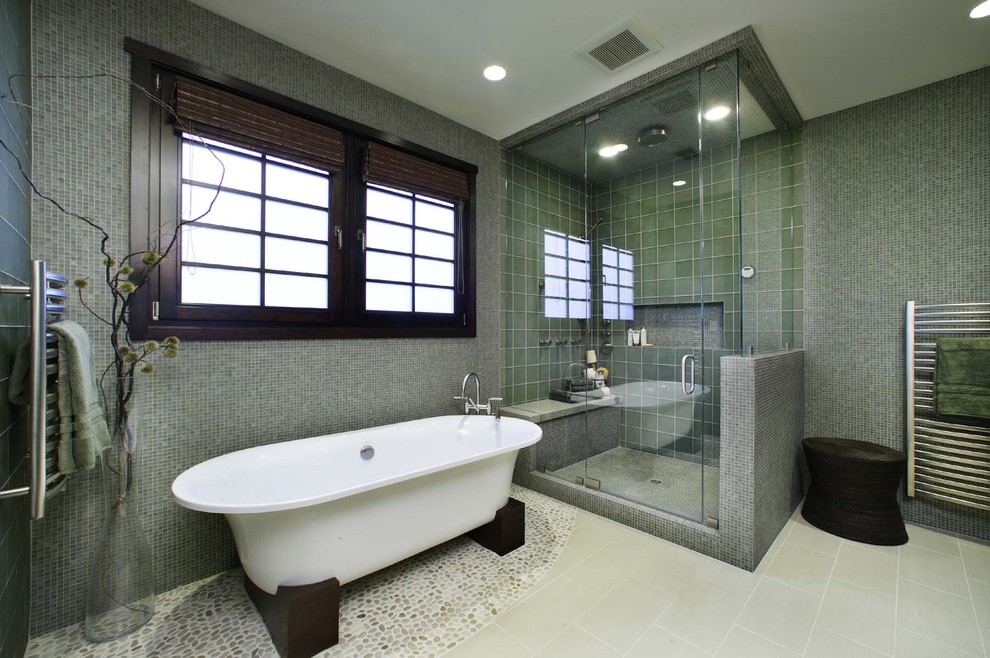 Bild på ett funkis badrum, med ett fristående badkar, mosaik och klinkergolv i småsten