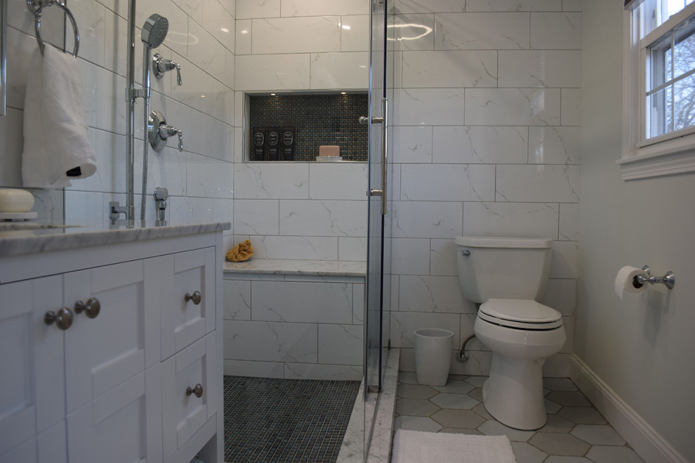 Medium sized contemporary ensuite bathroom in Boston with shaker cabinets, white cabinets, a corner shower, a two-piece toilet, white tiles, porcelain tiles, grey walls, porcelain flooring, a submerged sink, marble worktops, blue floors, a sliding door and white worktops.