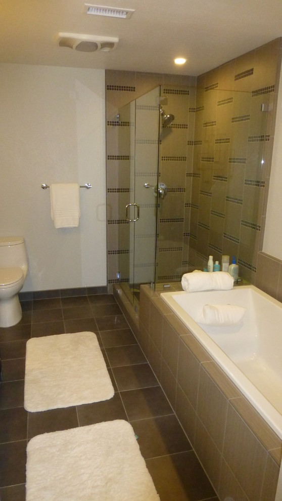 Esempio di una stanza da bagno padronale moderna di medie dimensioni con vasca da incasso, doccia ad angolo, WC a due pezzi, piastrelle marroni, piastrelle in pietra, pareti bianche e pavimento in ardesia