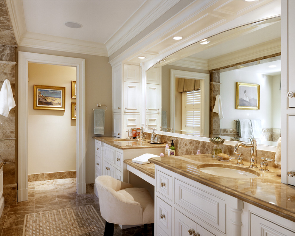 Свежая идея для дизайна: большая главная ванная комната в классическом стиле с фасадами с выступающей филенкой, белыми фасадами, полновстраиваемой ванной, унитазом-моноблоком, бежевой плиткой, бежевыми стенами, мраморным полом, врезной раковиной, мраморной столешницей, разноцветным полом и душем с распашными дверями - отличное фото интерьера