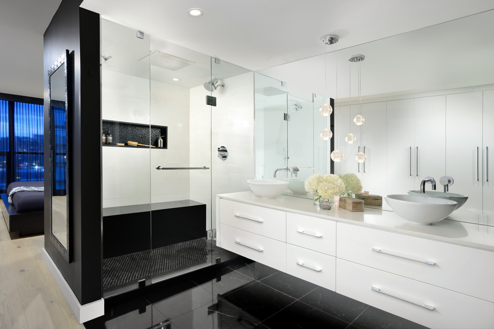Пример оригинального дизайна: большая главная ванная комната в стиле модернизм с плоскими фасадами, белыми фасадами, двойным душем, унитазом-моноблоком, черной плиткой, керамогранитной плиткой, черными стенами, полом из керамогранита, настольной раковиной, столешницей из искусственного кварца, черным полом, душем с распашными дверями и белой столешницей