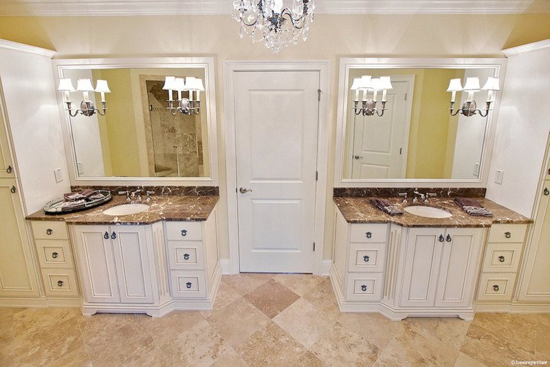 Idée de décoration pour une salle de bain principale tradition de taille moyenne avec un lavabo encastré, un placard avec porte à panneau encastré, des portes de placard blanches, un plan de toilette en marbre, un carrelage beige, un carrelage de pierre, un mur beige et un sol en travertin.