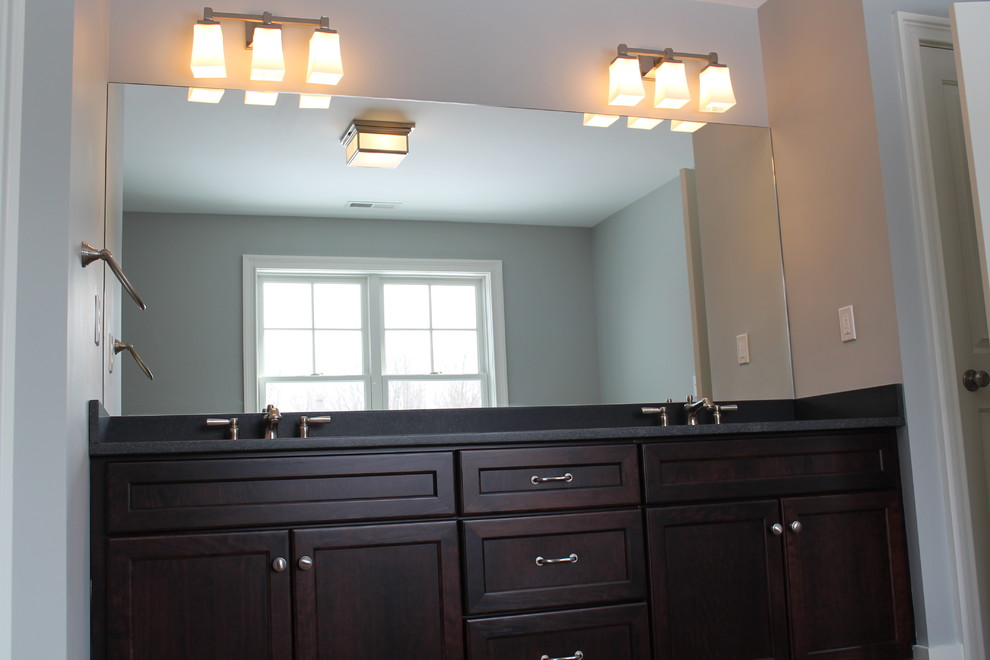 Modernes Badezimmer En Suite mit Schrankfronten mit vertiefter Füllung, dunklen Holzschränken, Granit-Waschbecken/Waschtisch, blauer Wandfarbe und Keramikboden in New York