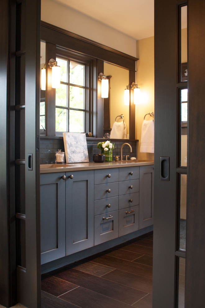 Diseño de cuarto de baño gris y negro tradicional con lavabo bajoencimera, armarios estilo shaker, baldosas y/o azulejos grises y puertas de armario negras
