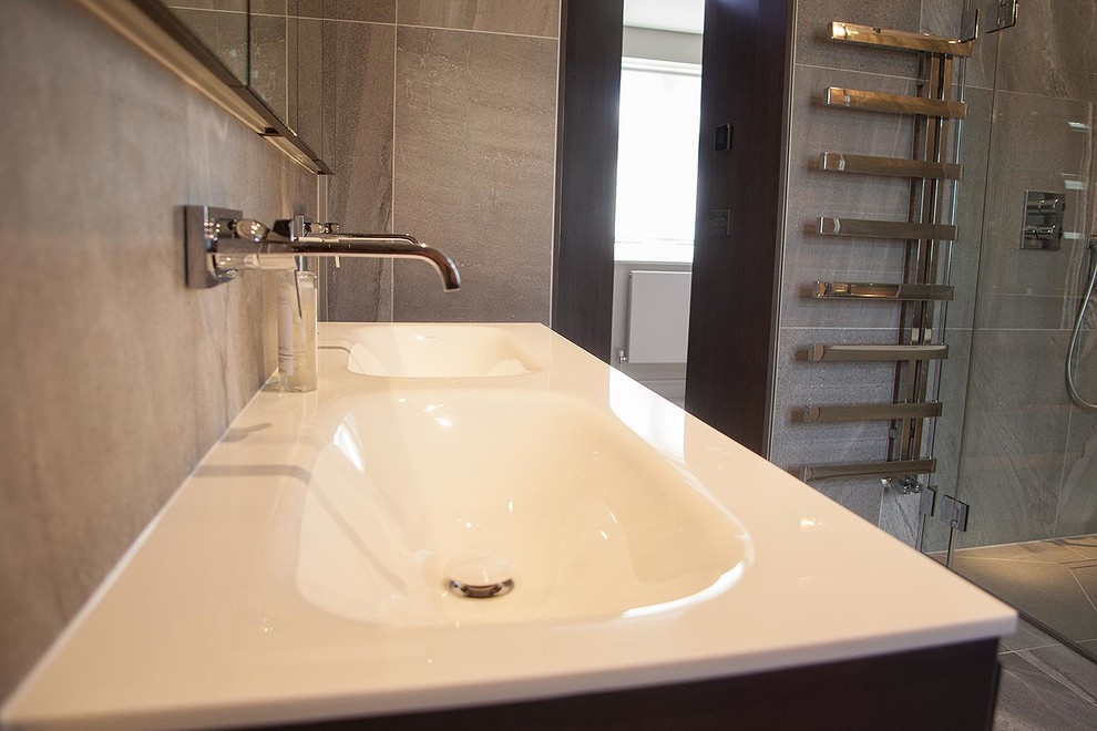 Modern inredning av ett stort badrum, med ett fristående badkar, en öppen dusch, en vägghängd toalettstol, grå kakel, porslinskakel, grå väggar, klinkergolv i porslin och ett nedsänkt handfat
