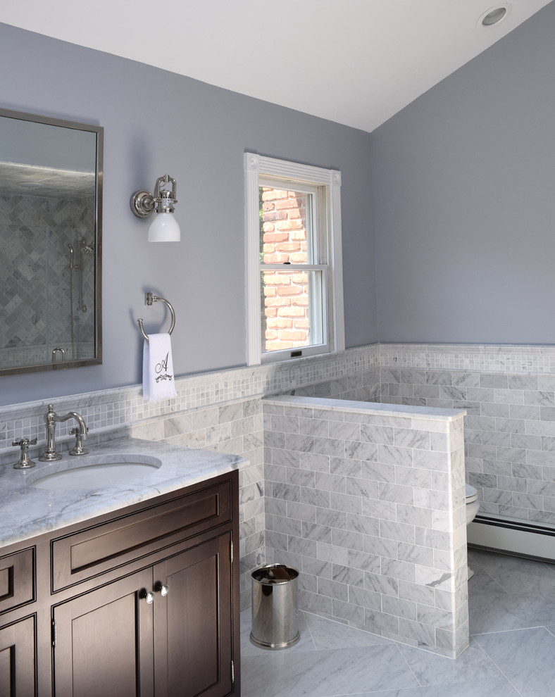 Example of a mid-sized classic master stone tile marble floor alcove shower design in New York with an undermount sink, recessed-panel cabinets, dark wood cabinets, quartzite countertops, a two-piece toilet and gray walls