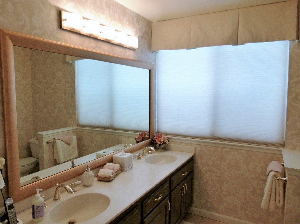 Пример оригинального дизайна: главная ванная комната среднего размера в стиле неоклассика (современная классика) с фасадами с выступающей филенкой, коричневыми фасадами, угловым душем, раздельным унитазом, розовыми стенами, полом из керамической плитки, монолитной раковиной, столешницей из искусственного кварца, розовым полом, душем с распашными дверями и белой столешницей