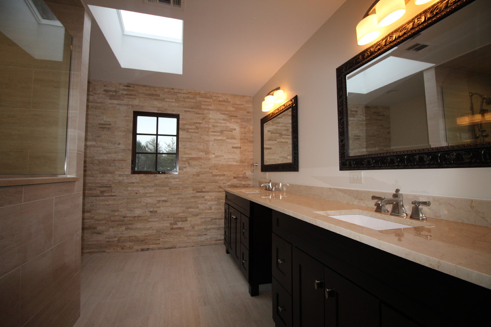 Inredning av ett klassiskt mellanstort en-suite badrum, med skåp i shakerstil, svarta skåp, en öppen dusch, en toalettstol med hel cisternkåpa, beige kakel, stenkakel, klinkergolv i porslin, ett undermonterad handfat och granitbänkskiva