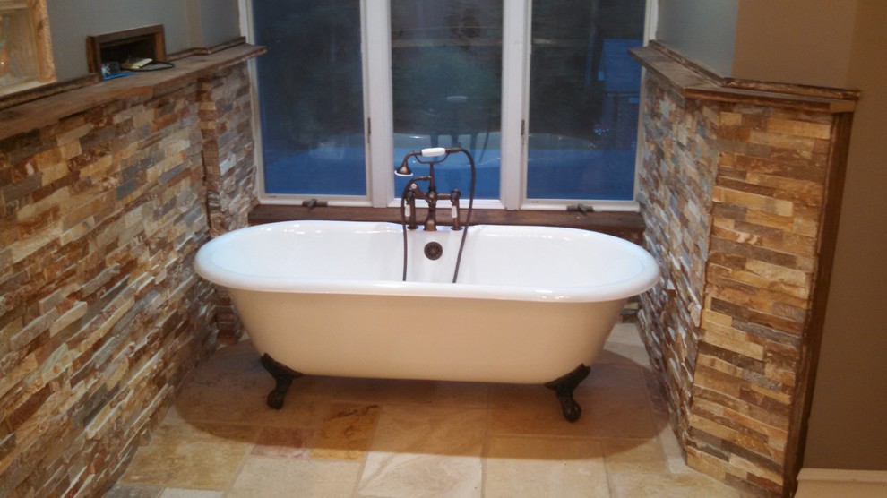 Foto de cuarto de baño principal rústico grande con bañera con patas, ducha abierta, paredes azules, suelo de piedra caliza y suelo marrón