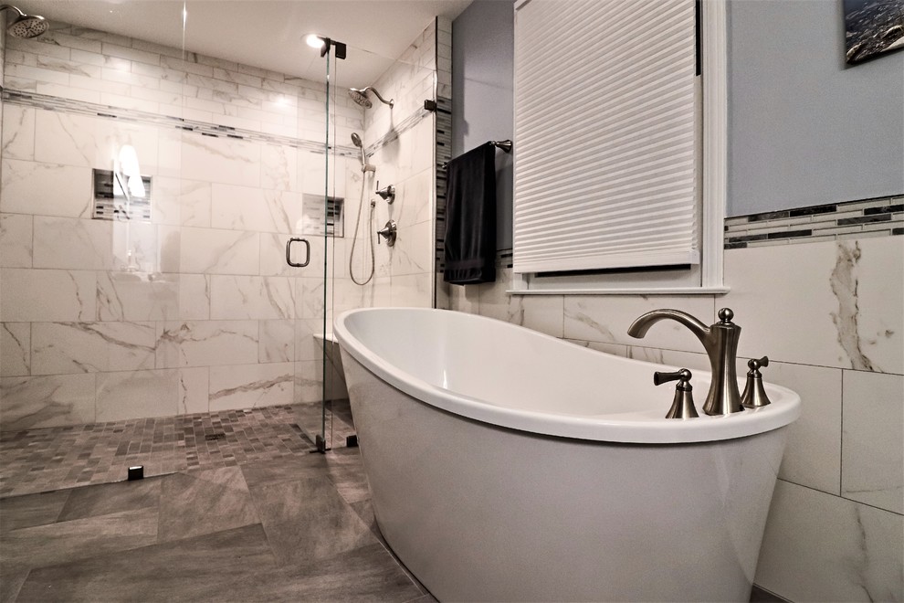 Klassisk inredning av ett stort grå grått en-suite badrum, med skåp i shakerstil, vita skåp, ett fristående badkar, en kantlös dusch, en toalettstol med separat cisternkåpa, vit kakel, porslinskakel, blå väggar, klinkergolv i porslin, ett undermonterad handfat, marmorbänkskiva, grått golv och dusch med gångjärnsdörr