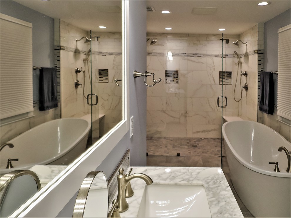 Exempel på ett stort klassiskt grå grått en-suite badrum, med skåp i shakerstil, vita skåp, ett fristående badkar, en kantlös dusch, en toalettstol med separat cisternkåpa, vit kakel, porslinskakel, blå väggar, klinkergolv i porslin, ett undermonterad handfat, marmorbänkskiva, grått golv och dusch med gångjärnsdörr