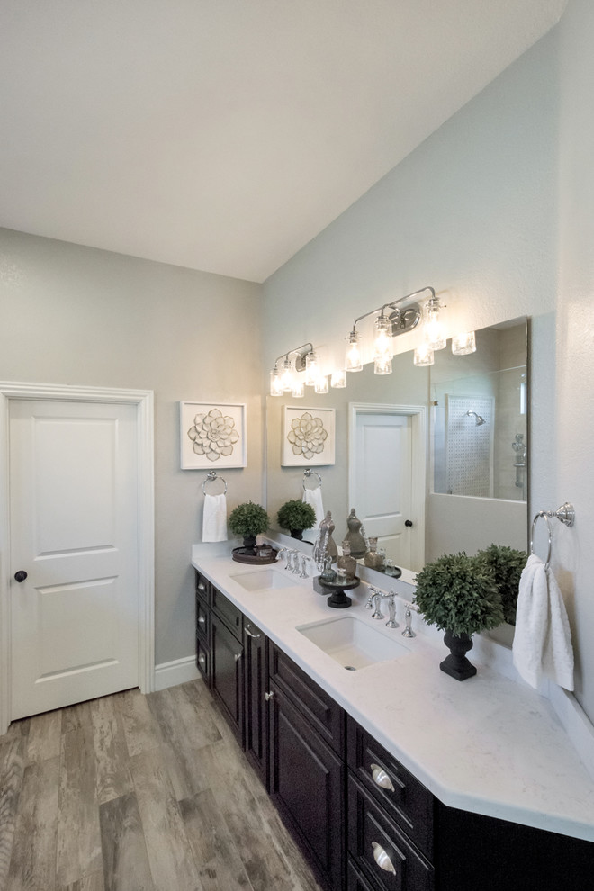 Bathroom - mid-sized traditional master beige tile and porcelain tile porcelain tile and gray floor bathroom idea in Phoenix with raised-panel cabinets, black cabinets, a one-piece toilet, gray walls, a drop-in sink and quartzite countertops