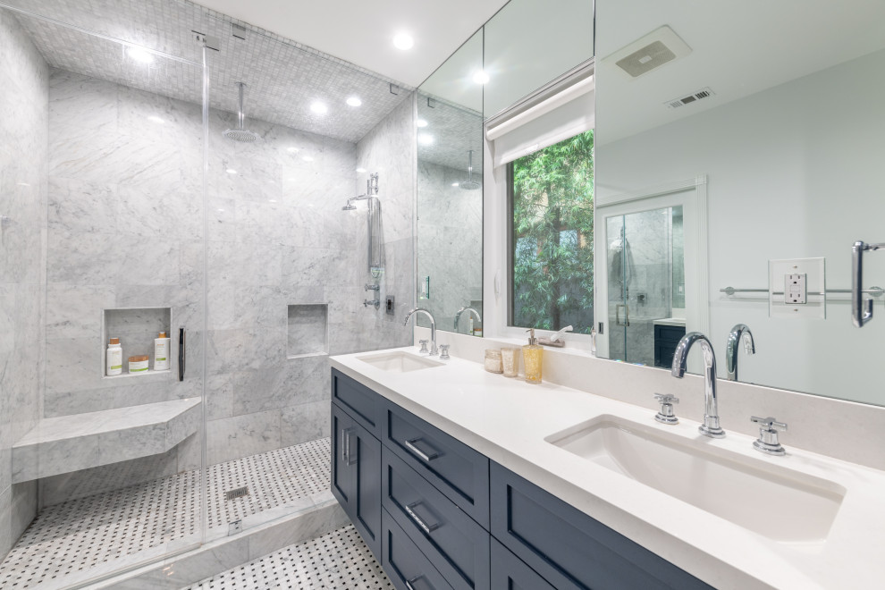 Inredning av ett klassiskt stort vit vitt en-suite badrum, med skåp i shakerstil, blå skåp, en dusch i en alkov, en toalettstol med hel cisternkåpa, grå kakel, porslinskakel, vita väggar, marmorgolv, ett undermonterad handfat, bänkskiva i kvarts, dusch med gångjärnsdörr och grått golv