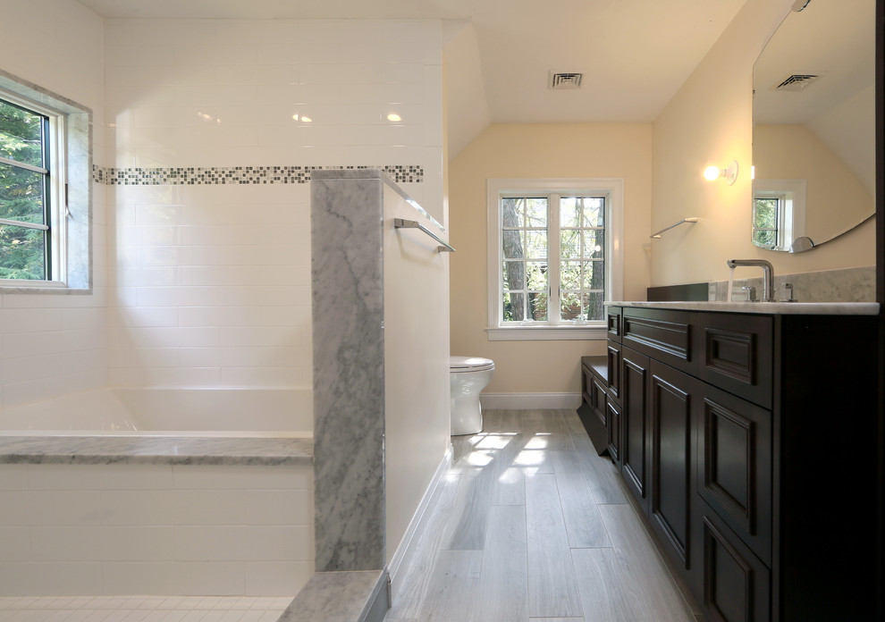 Idéer för stora vintage en-suite badrum, med luckor med infälld panel, skåp i mörkt trä, ett platsbyggt badkar, en öppen dusch, grå kakel, vit kakel, tunnelbanekakel, gula väggar, ljust trägolv, ett undermonterad handfat, marmorbänkskiva, grått golv och med dusch som är öppen