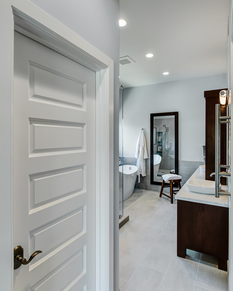 Example of a large trendy master gray tile and porcelain tile porcelain tile bathroom design in San Francisco with a vessel sink, flat-panel cabinets, dark wood cabinets, quartz countertops, a wall-mount toilet and gray walls