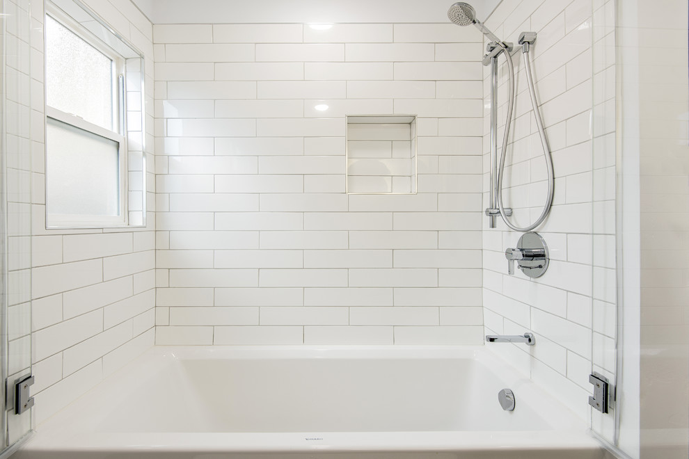 This is an example of a large modern ensuite bathroom in San Francisco with flat-panel cabinets, brown cabinets, a built-in bath, a walk-in shower, a wall mounted toilet, white tiles, metro tiles, white walls, mosaic tile flooring, a built-in sink, quartz worktops, black floors, a hinged door and white worktops.