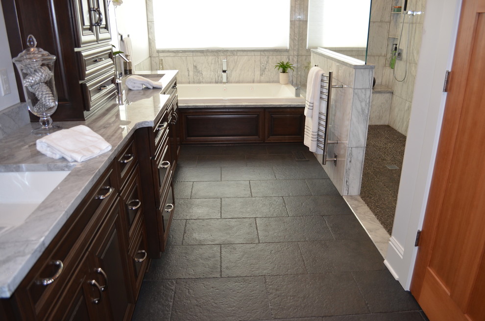 Exemple d'une salle de bain chic en bois foncé avec un lavabo encastré, un placard avec porte à panneau encastré, un plan de toilette en marbre, une baignoire posée, WC à poser, un carrelage noir et des carreaux de porcelaine.