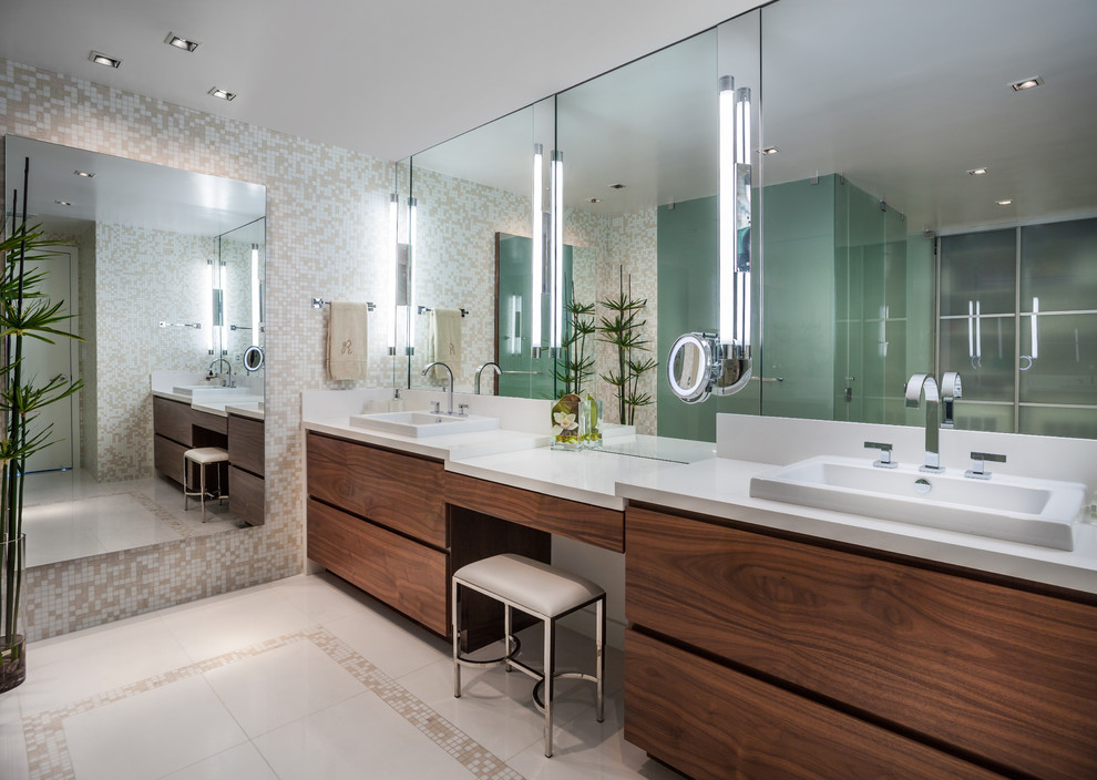 Example of a large trendy master beige tile and mosaic tile ceramic tile and beige floor corner shower design in Miami with a vessel sink, flat-panel cabinets, multicolored walls, solid surface countertops, dark wood cabinets, a two-piece toilet and a hinged shower door